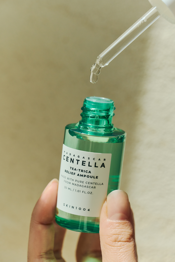 YABUKO SKIN1004 Madagascar Centella Tea-Trica reljefa ampula, nomierinoša ādas kopšanas seruma pudele uz balta fona
